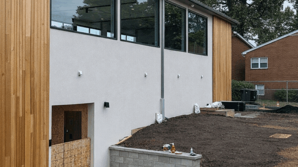 Gutter and Window Installation | Tycos Roofing And Siding Inc Building side with large windows and visible gutter downspout.