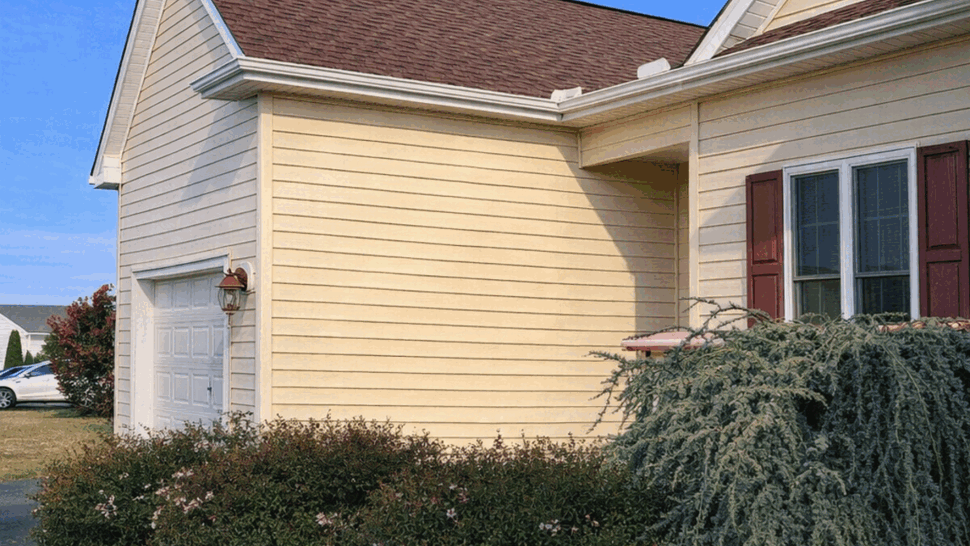 Seamless Gutters on Garage Eaves | Tycos Roofing And Siding Inc Side view of garage gable with white seamless gutters and beige siding