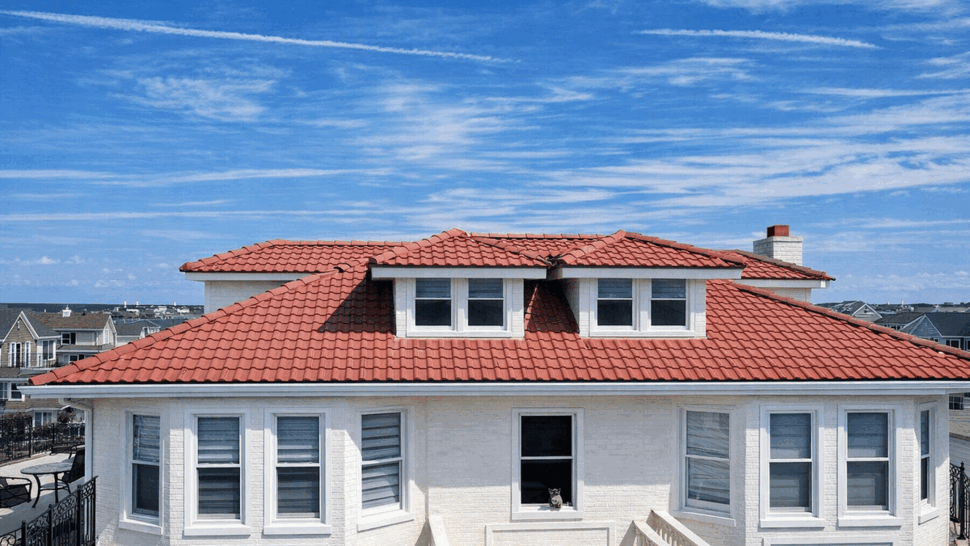 Dormer Windows and Tile Roof Front Elevation | Tycos Roofing And Siding Inc Front elevation of white home with dormer windows and red tile roof under blue sky