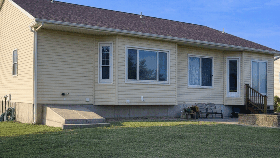 Back of house with large replacement windows and small patio steps