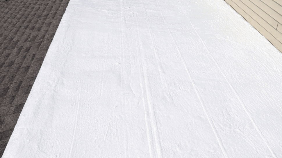 White Flat Roof Coating Repair | Tycos Roofing And Siding Inc Fresh white coating applied to a flat roof area next to shingled roof