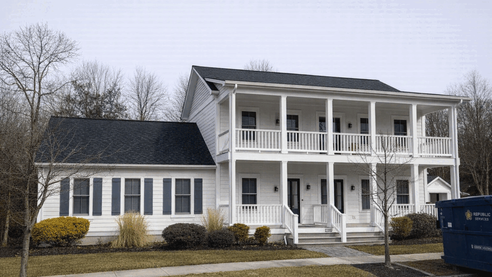 Two-story house with porch | Tycos Roofing And Siding Inc Two-story white house with large covered porch and dark shingle roof.