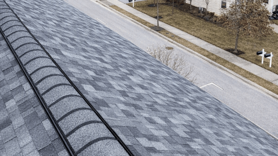 Aerial view along a roof ridge with ridge vent looking over a residential neighborhood