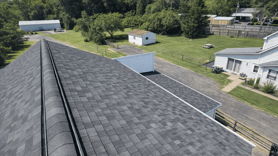 Overhead shingle roof and yard | Tycos Roofing And Siding Inc Overhead view of a dark shingle roof, adjacent yard and a small outbuilding
