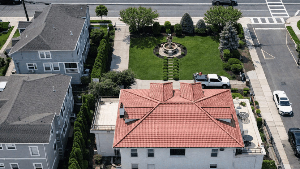 Aerial Roof and Yard Inspection | Tycos Roofing And Siding Inc Aerial shot showing tiled roof, circular fountain in yard, and surrounding street