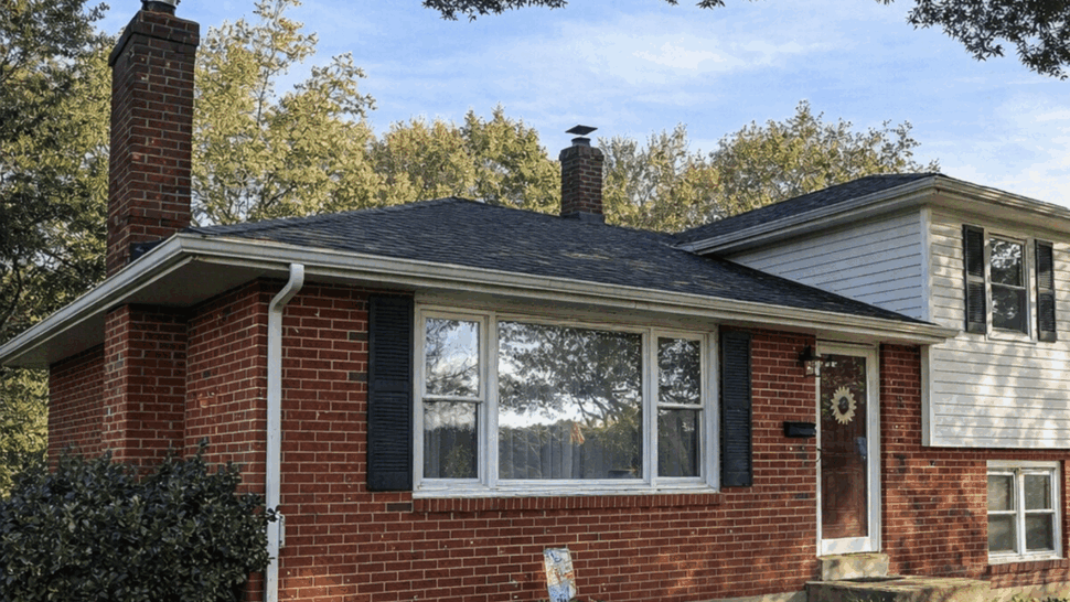 Front Home Roofing View | Tycos Roofing And Siding Inc Front view of a brick home with shingle roof, chimney, and gutters