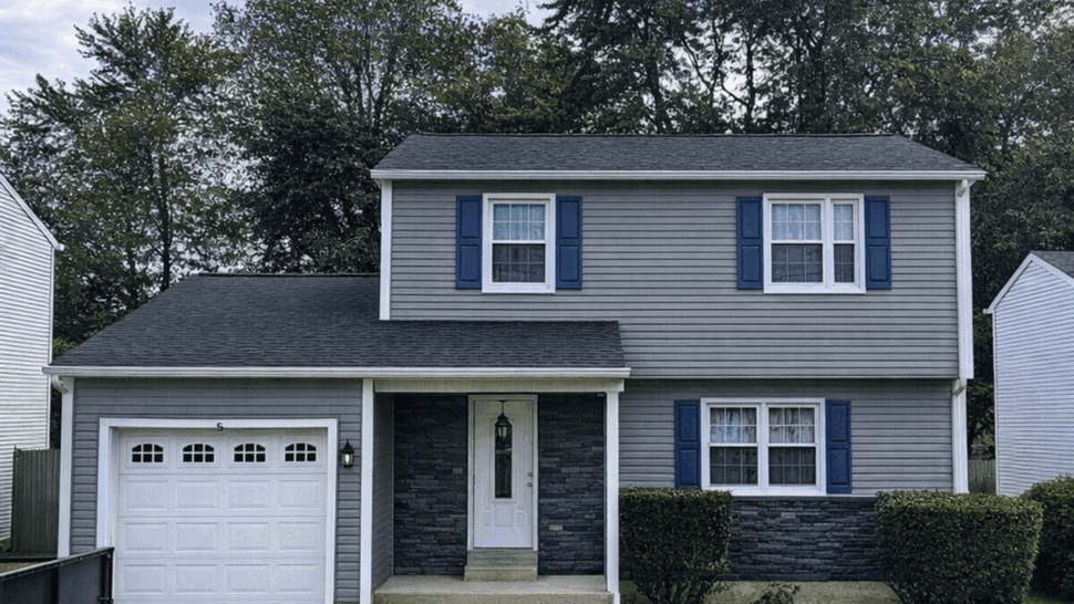 Gray Home Roof and Siding | Tycos Roofing And Siding Inc Gray two-story home with dark roof, gray siding, blue shutters, and attached garage