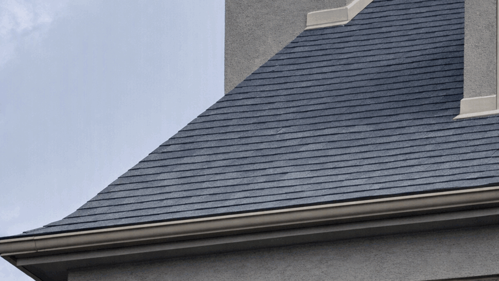Chimney and Gutter Roof Detail | Tycos Roofing And Siding Inc Shingled roof slope, stucco chimney and seamless gutter along the eave.
