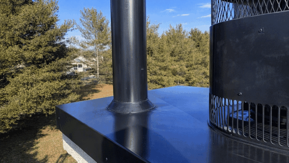 Close-up of black chimney cap and metal flashing on chimney crown