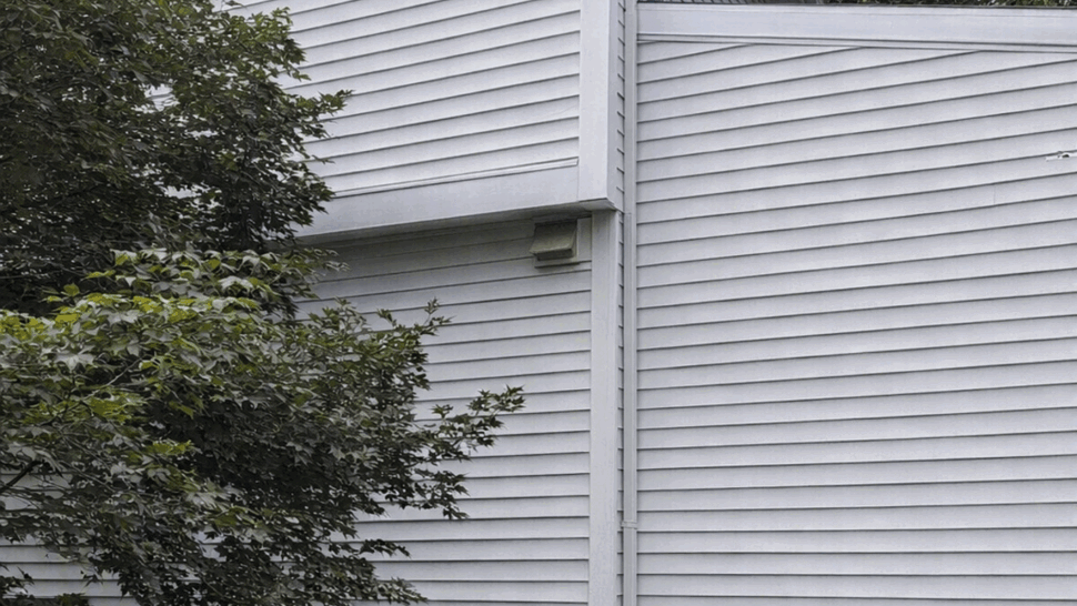 Side elevation showing vinyl siding, corner trim and foundation.
