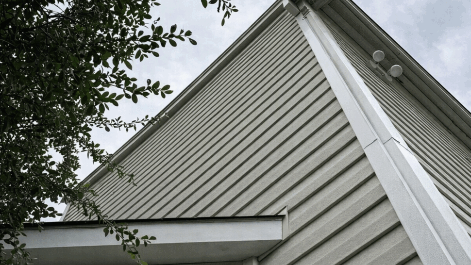 Gutter and Roofline Corner View | Tycos Roofing And Siding Inc Upward view of a house corner showing roofline and attached gutter.