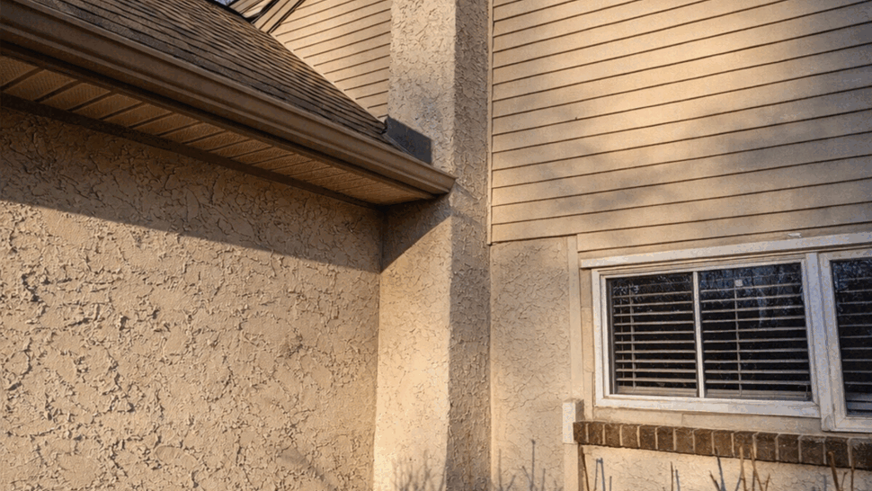 Close-up of chimney and siding corner with visible gutter and roofline