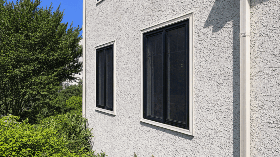 Gutter and downspout on two-story home | Tycos Roofing And Siding Inc Side of house showing gutter, downspout and two-story windows.