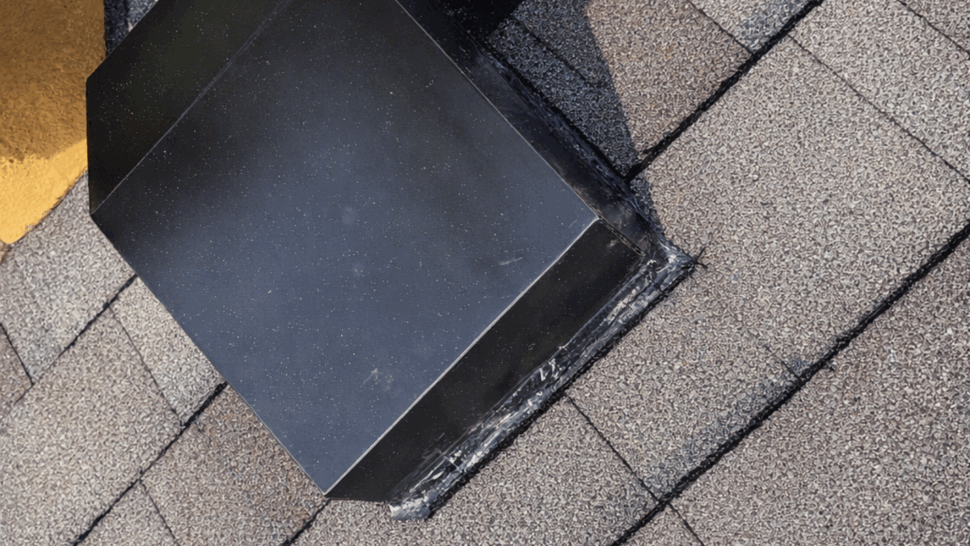 Angled view of vent flashing and sealant on shingle roof