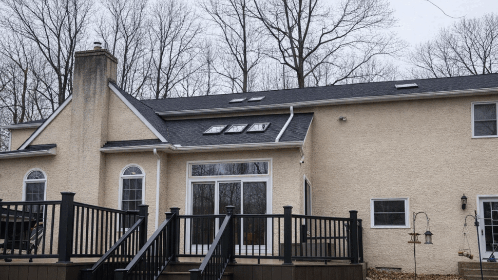 Back Deck with Skylights and Roof | Tycos Roofing And Siding Inc Back deck with black railing, sliding glass door and shingled roof with skylights