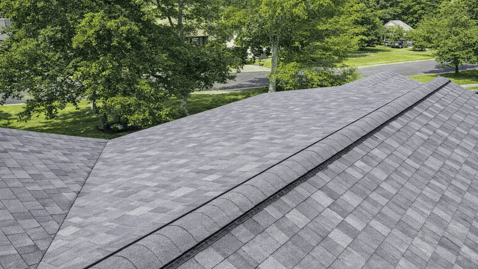 Close-up of gray asphalt shingle roof ridge with a ventilated ridge cap.