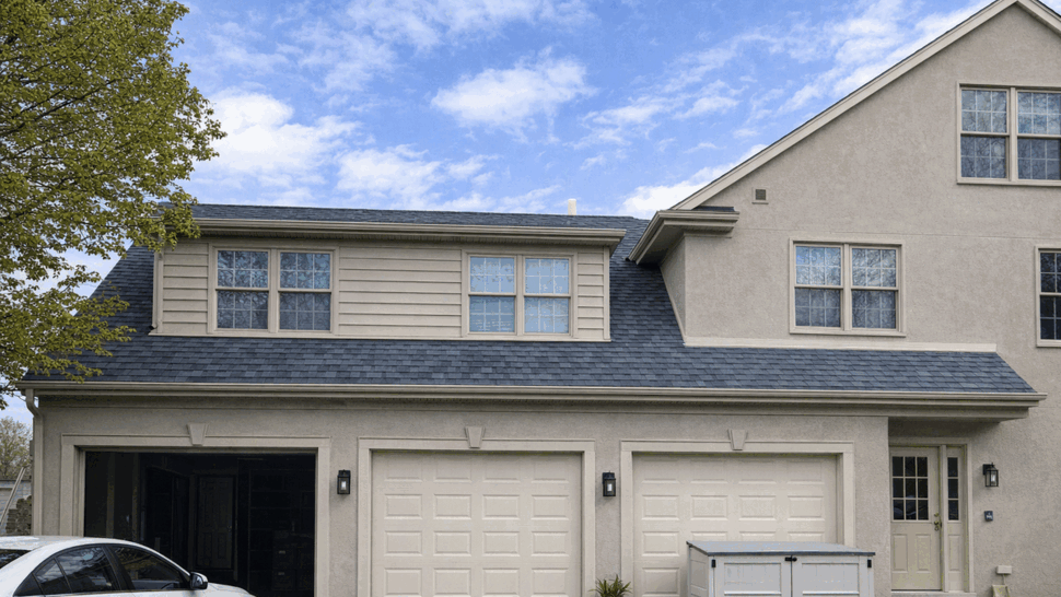 Garage Dormer with New Roof and Windows | Tycos Roofing And Siding Inc Three-car garage with dormer windows and new dark roof shingles.