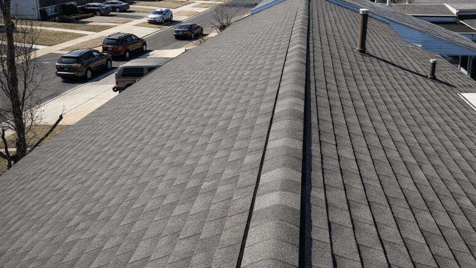 Aerial view of a gray asphalt shingle roof in a residential neighborhood