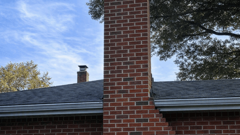 Chimney and Shingle Roof | Tycos Roofing And Siding Inc Brick chimney rising above a shingle roof and gutter line