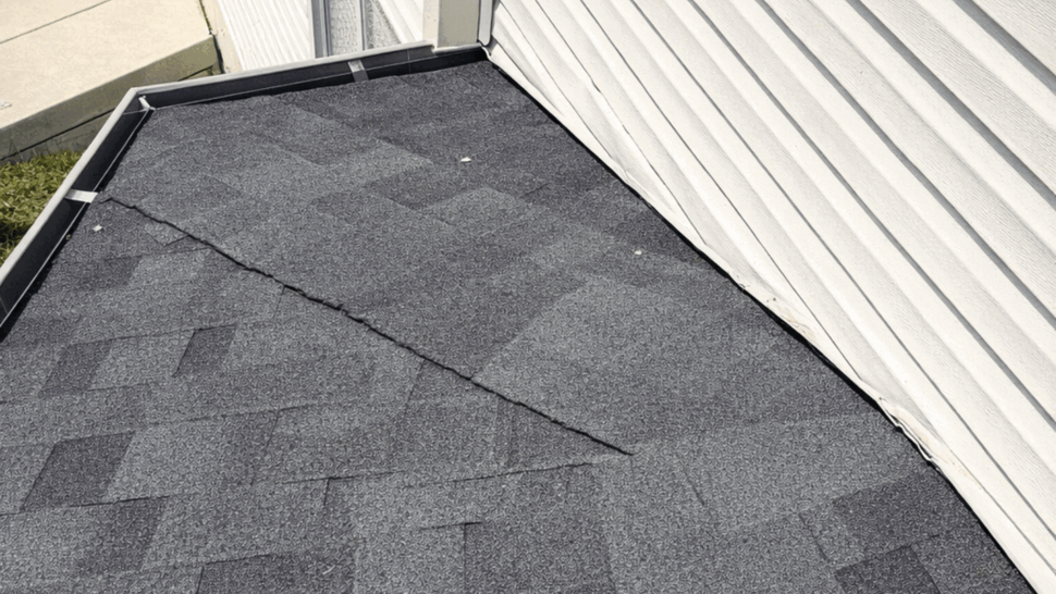Close-up of shingles meeting vinyl siding at a roof junction