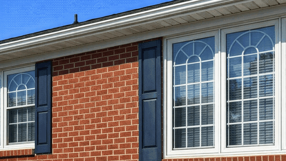 Window and gutter detail on brick home | Tycos Roofing And Siding Inc Close-up of brick wall, decorative window panes and gutter eave