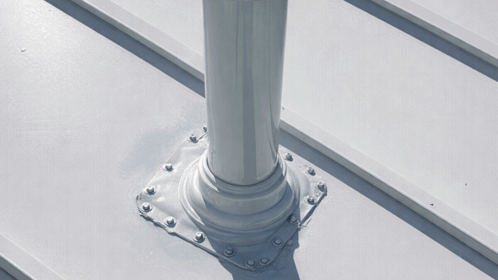 Metal Roof Vent Flashing Detail | Tycos Roofing And Siding Inc Close-up of a vent pipe with sealed metal flashing on a metal roof.