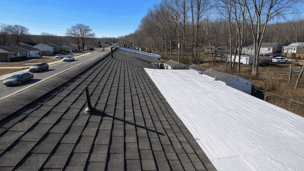 Residential roof with dark shingles, vents, and a white membrane section