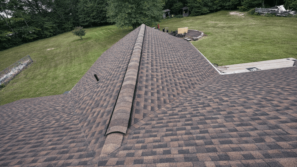 Close-up view of asphalt roof ridge and shingles looking down