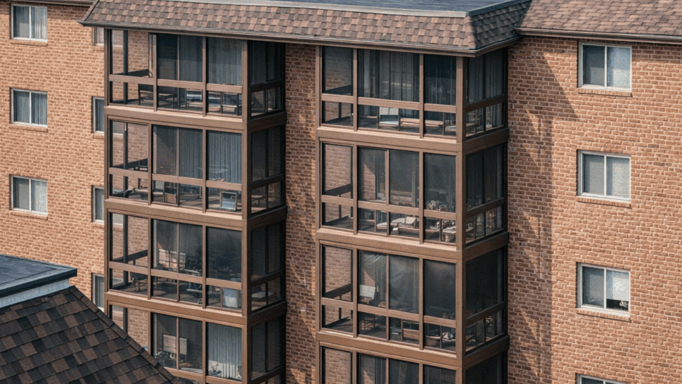 High-angle view of a shingle roof on a brick apartment complex.