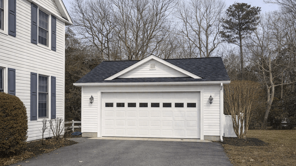 Detached garage with double door | Tycos Roofing And Siding Inc Detached white garage with double panel door and gabled roof.