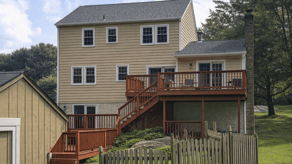 Raised wooden deck and stairs | Tycos Roofing And Siding Inc Rear of house showing raised wooden deck with stairs and siding