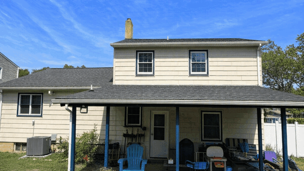 Rear Home Roofing and Siding | Tycos Roofing And Siding Inc Rear view of a home with gray roofing, light siding, and a covered porch.