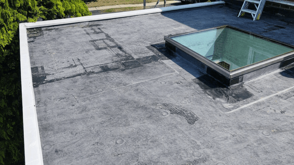Close detail of skylight flashing and repairs on flat roof
