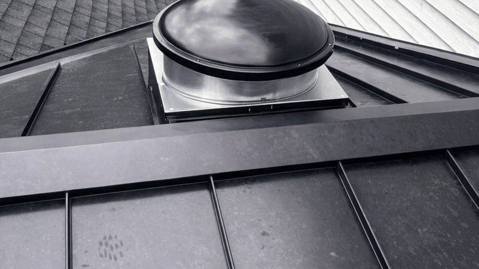 Round tubular skylight dome mounted on a black metal roof