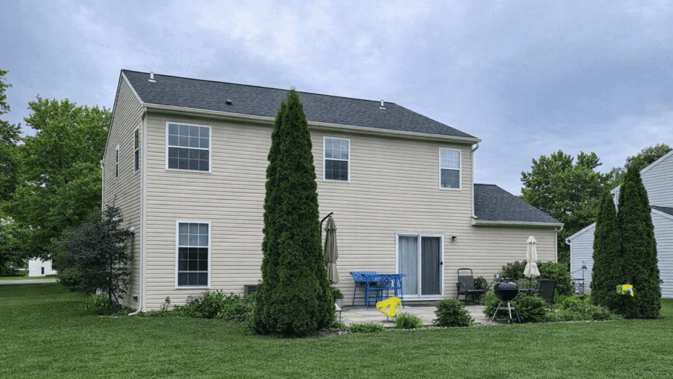 Rear Roof Shingle Overview | Tycos Roofing And Siding Inc Rear view of house showing dark shingle roof, windows and small patio