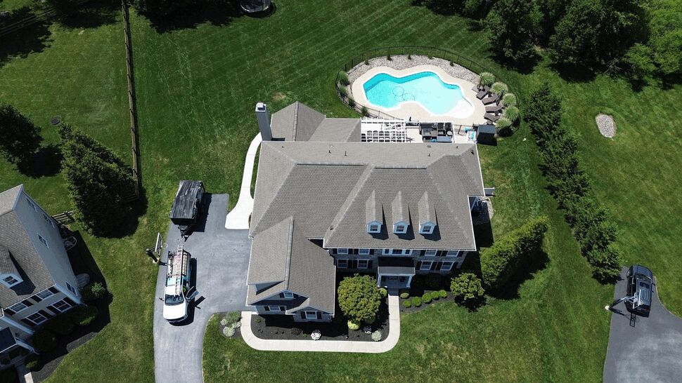 Aerial view of house, pool and Tycos service trucks in driveway