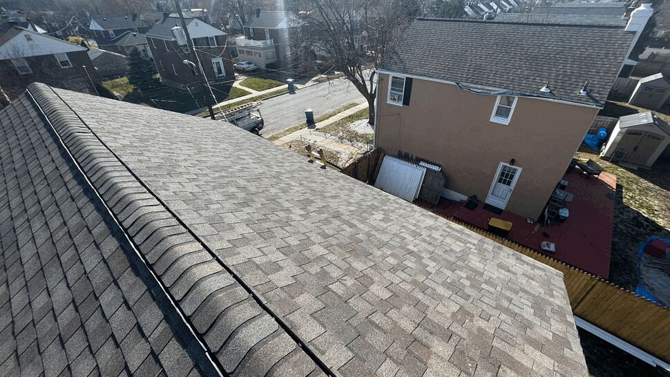 Aerial view of roof ridge overlooking neighboring houses and yard