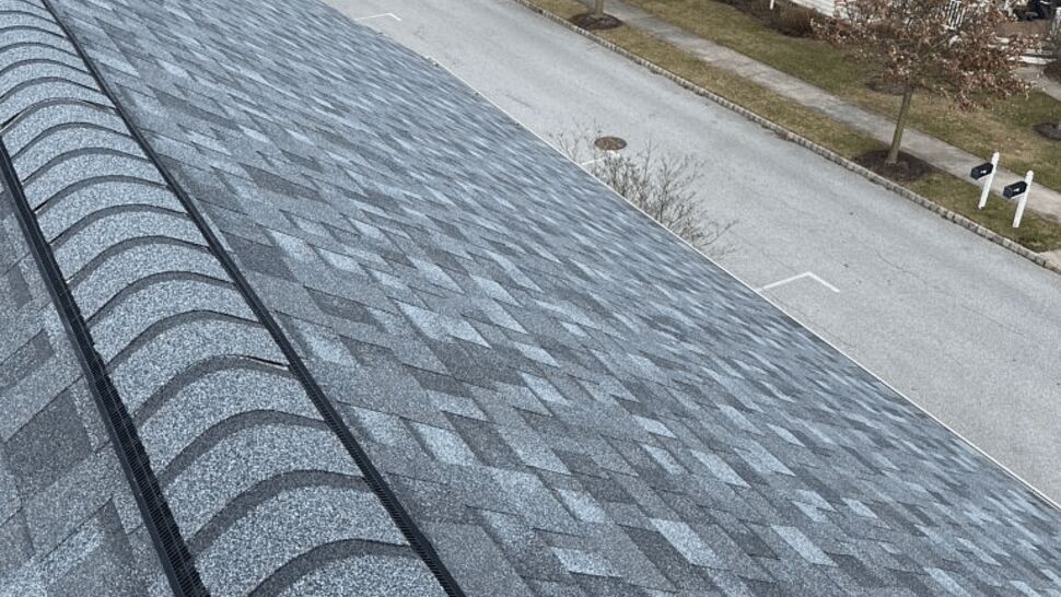 Aerial view along a roof ridge with ridge vent looking over a residential neighborhood
