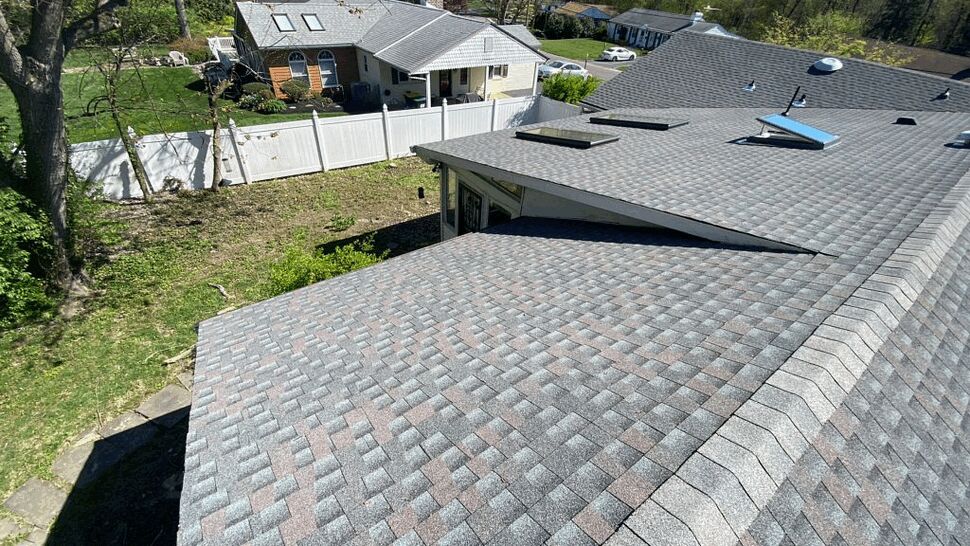 Aerial view of patterned asphalt shingle roof with skylights