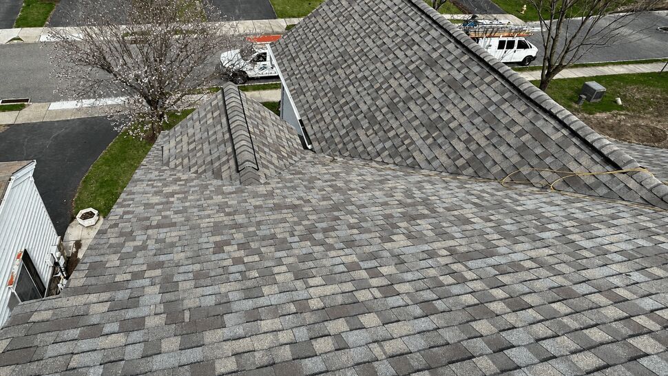 Aerial view of installed asphalt shingles across multiple roof planes.