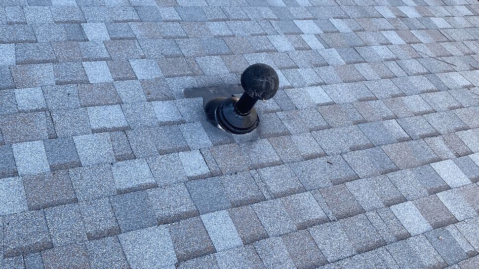 Gray asphalt shingle roof with a black vent pipe near the center of the slope.