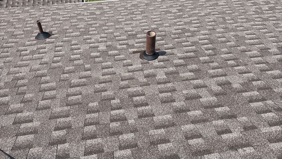 Asphalt Shingle Roof with Vents | Tycos Roofing And Siding Inc Aerial view of asphalt shingle roof with two vent pipes and lawn below