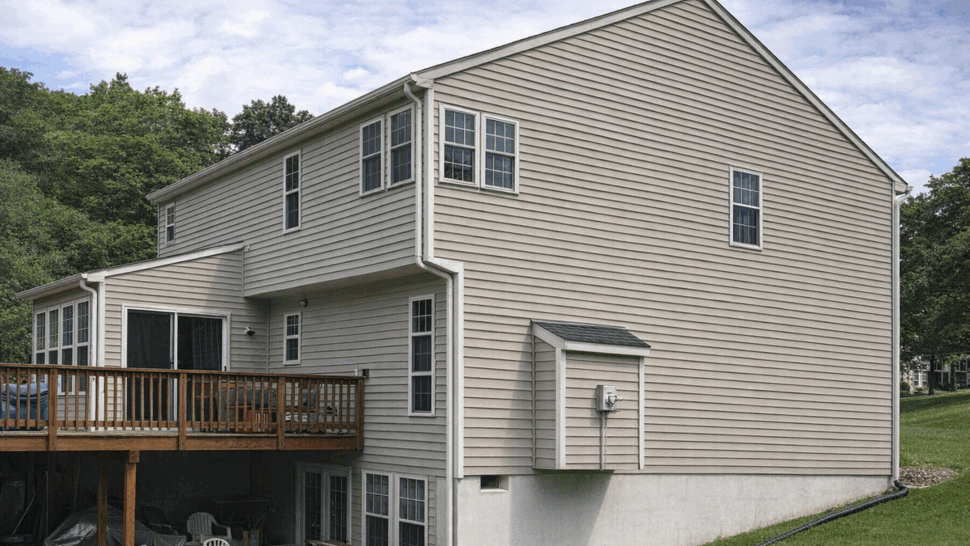 Rear view with wooden deck | Tycos Roofing And Siding Inc Back of house with wooden deck, vinyl siding and basement patio area.
