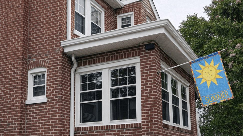 Brick Sunroom Window Upgrade | Tycos Roofing And Siding Inc Brick sunroom with multiple white windows and a gutter downspout