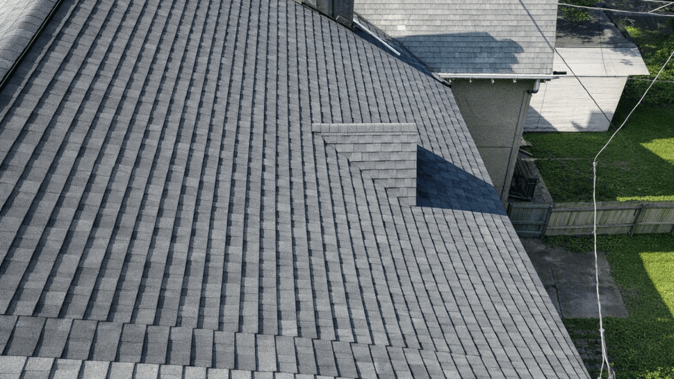 Angled shingle roof with dormer | Tycos Roofing And Siding Inc Close angled view of a shingle roof with a small dormer and neat ridge lines.