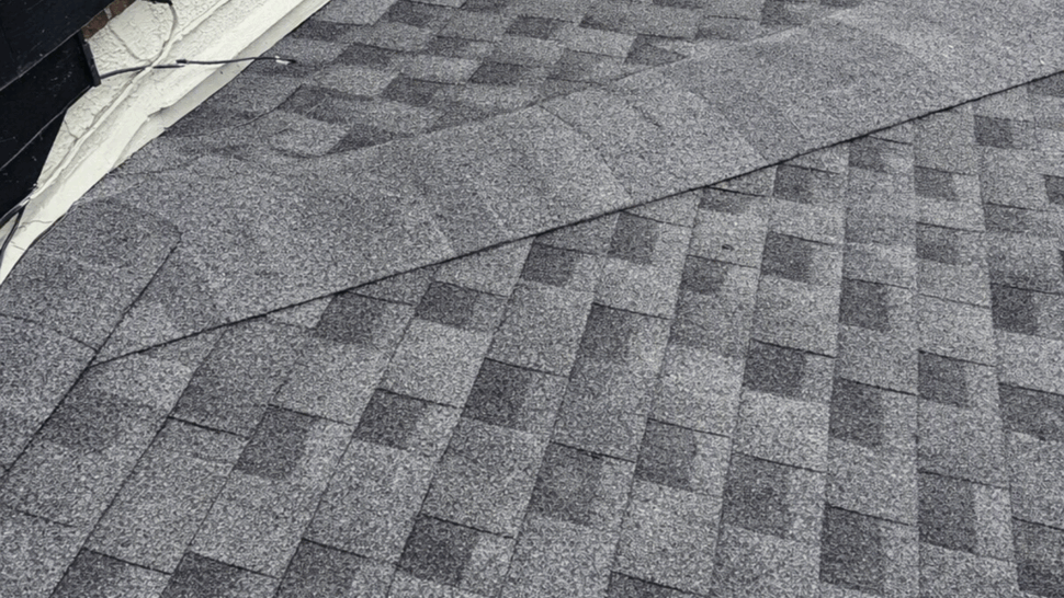 Close-up view of gray asphalt shingles on a sloped roof.