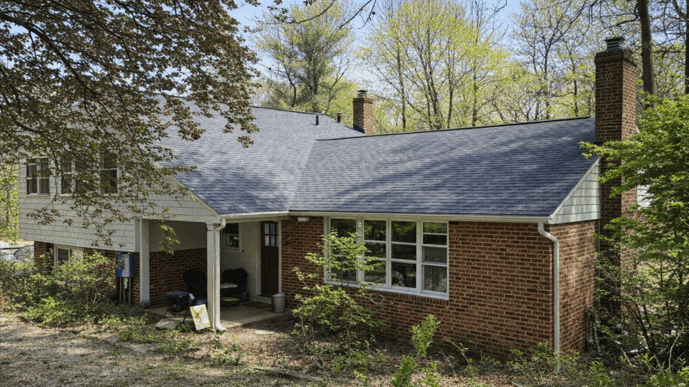 Brick house porch with siding, windows and gutters on a shaded lot