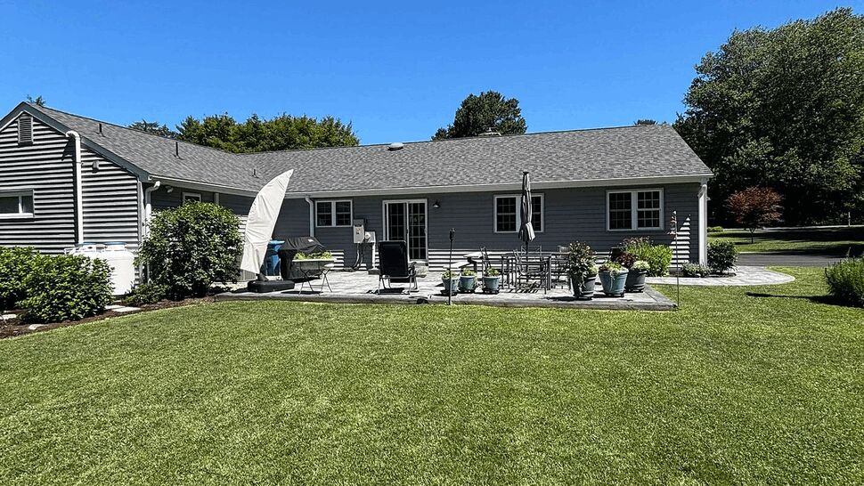 Backyard patio with outdoor furniture and low roofline