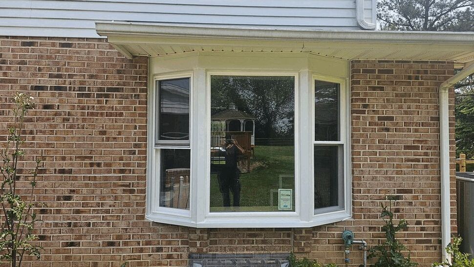 Bay Window Replacement on Brick Home | Tycos Roofing And Siding Inc Projecting bay window with white trim on a red brick exterior