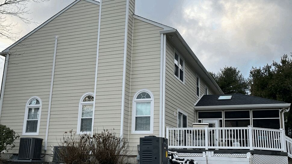 Beige siding house with white deck and screened room off the back
